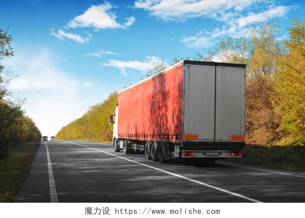 蓝天下高速公路上行驶的货车农村道路上的卡车和拖车，有文字的空间，秋天的森林，蓝天，有云彩